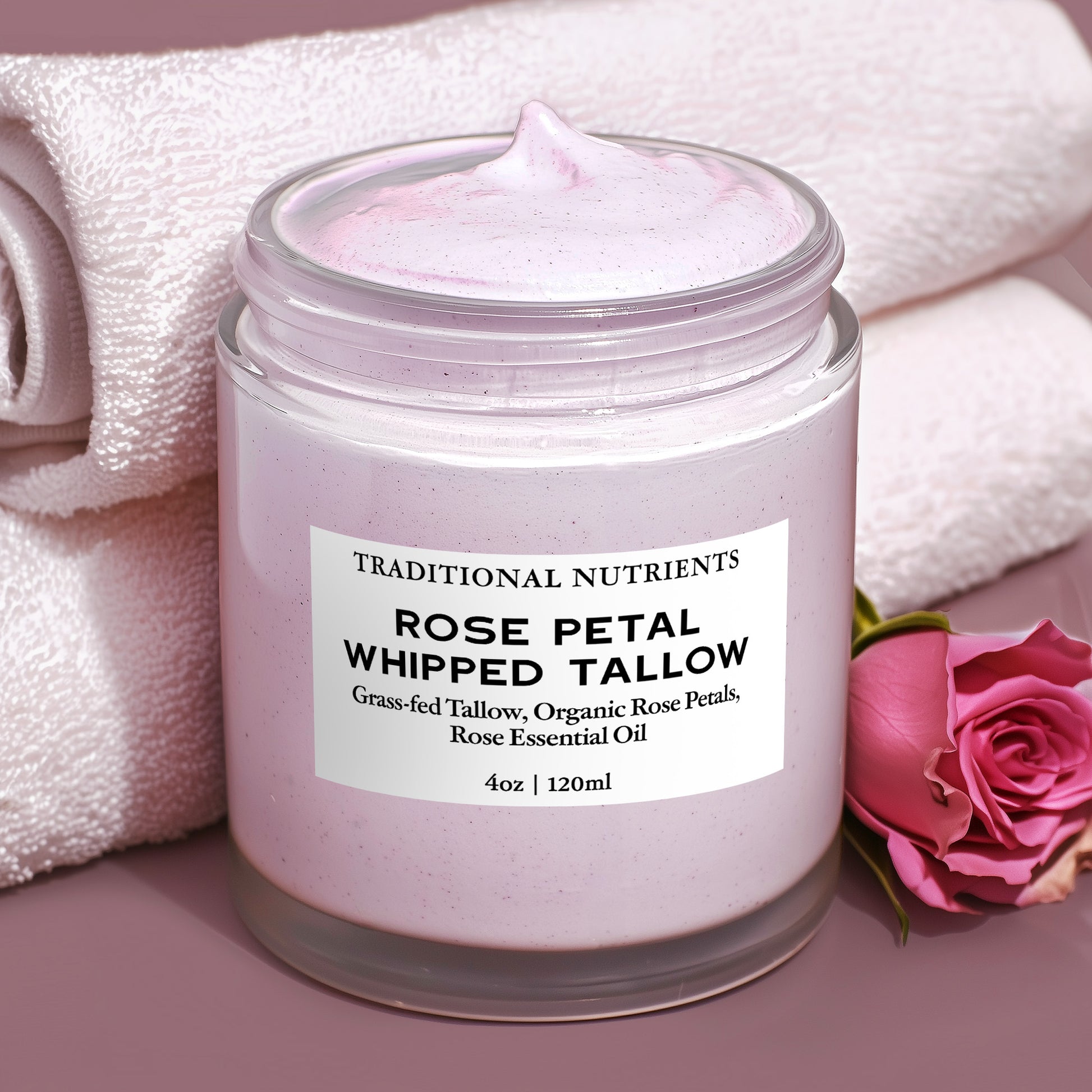 Jar of rose petal whipped tallow with a label on a pink background